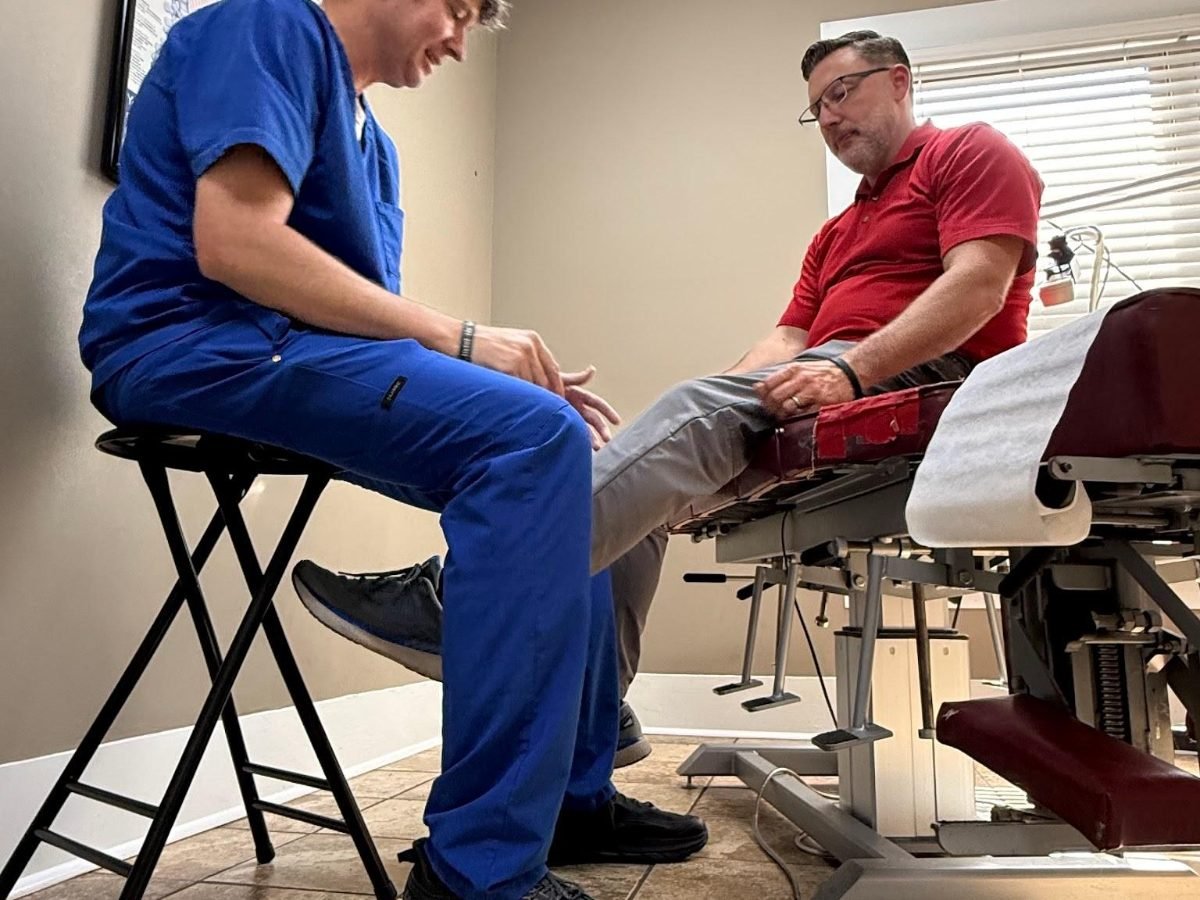 Dr. Channing King, DC evaluating a patient's knee at King Family Chiropractic in Trussville, Alabama
